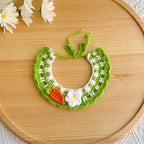 Flat-lay of artisan carrot knit pet collar on wooden tray
